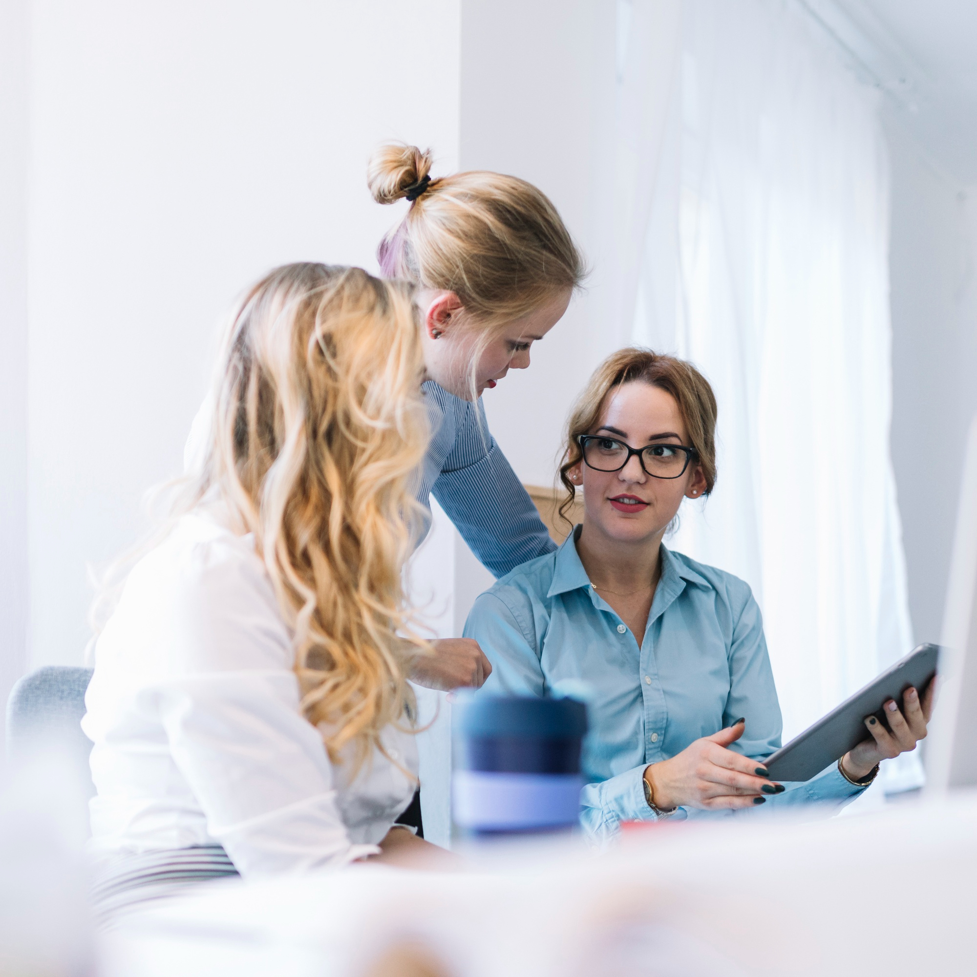 The image should represent a professional and welcoming atmosphere, emphasizing the core services offered by the accounting firm located in Belarus. It should depict elements such as an office environment with modern technology, showcasing a team of accountants working collaboratively. The scene should convey trust and expertise, highlighting the firm's commitment to delivering high-quality accounting services. Key elements might include a focus on a central figure discussing financial reports or data analysis on a computer screen, symbolizing precision and attention to detail.